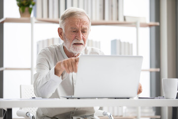 senior man using laptop computer and serious at work