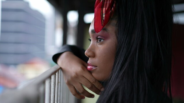 Young Woman Standing At Balcony Staring Outside In Contemplation Close-up Face Lost In Thought