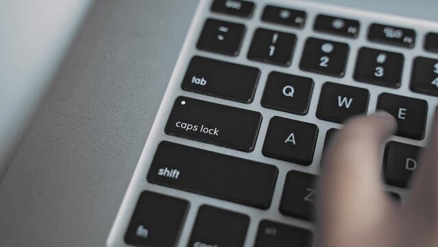 Typing on laptop keyboard, pressing the Caps Lock button