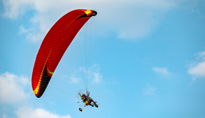 Paramotor Flying through sunlight with Blue Sky.Adventure man active extreme sport pilot flying in...