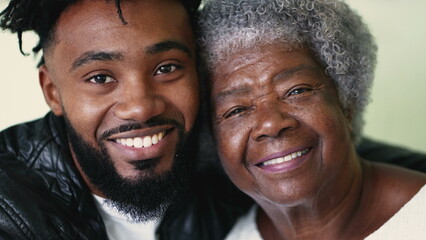 Adult grandson embracing senior grandmother authentic and real life