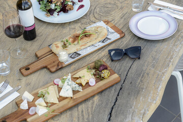 Wine and cheese meal , Cheeses on a wooden surface, cheese and wine meal , White wine and cheese platter for outdoor dinner in a garden , white wine on wooden background