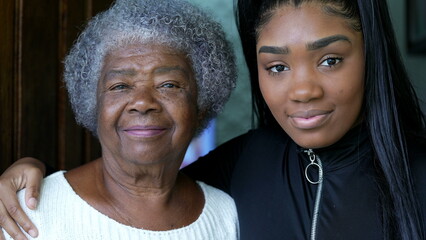 A teen granddaughter embracing grandmother a black girl embraces grandparent - obrazy, fototapety, plakaty