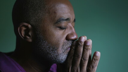 A south american senior black man praying to God