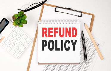 Office desk table with paper sheet, notepad ,chart and calculator. Top view, text RETURN POLICY
