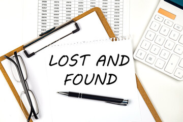 Text LOST AND FOUND on the white paper on clipboard with chart and calculator