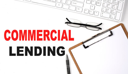 COMMERCIAL LENDING text written on white background with keyboard, paper sheet and pen