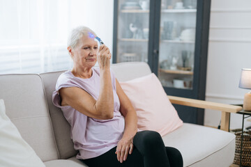 elderly woman sitting in a yoga pose in front of an open laptop.