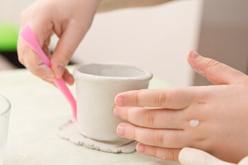 Working with natural clay. Old style pot production lessons for children. Children activities at home, school, extracurricular group. Handmade Pottery Cup Made by kid.