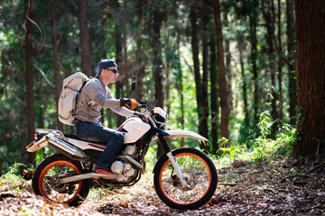 Fototapeta na wymiar オフロードバイクで山道を走る男性