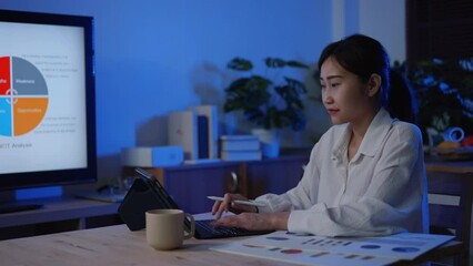 Young adult Asian businesswoman work with computer laptop for finance of business. woman with online learning with marketing class at night at home