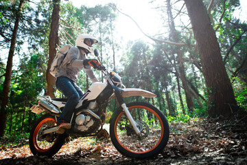 オフロードバイクで山道を走る男性