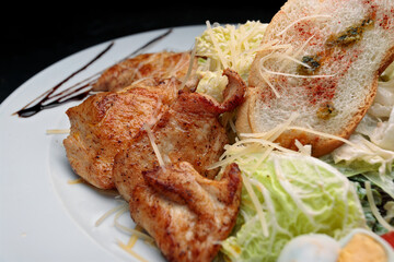 Salad with chicken fillet, eggs, on a black background with space for text