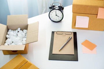 Small business owner packing in the card box at workplace. working room, work from home. home interior of open work space with white desk. home business online shipping and packing parcel box concept.