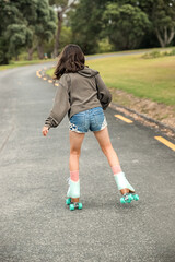portrait of young child or teen girl roller skating outdoors, firness, wellbeing, active healthy lifestyle. High quality photo