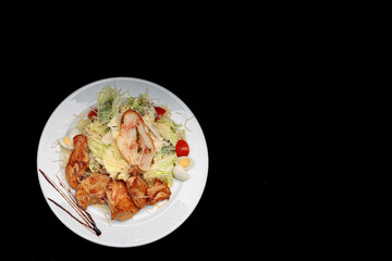 Chicken breast with salad, eggs, on a black background with space for text
