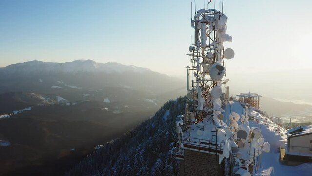 4k video. Communication GSM and internet data scaffolding with antennas on top of the mountains, winter landscape before sunset 