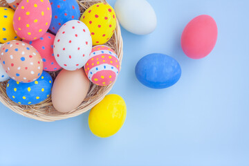 Colorful eggs in a basket on blue background	