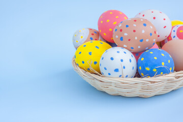 Colorful eggs in a basket on blue background	