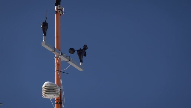 4k video. A small meteo station on top of a house against blue sky background. Meteorology as a hobby.