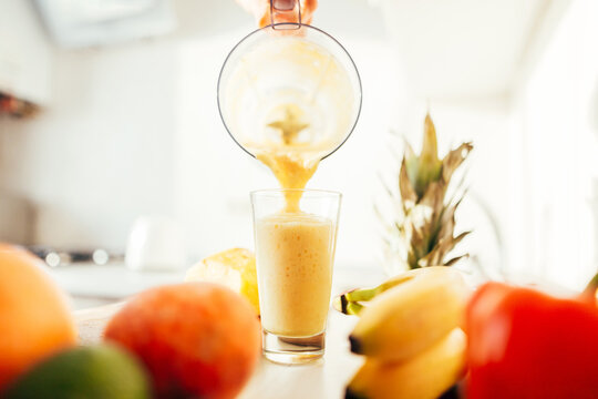 pouring fresh fruit smoothies into a glass. Peach, banana, apple. Close-up.Healthy food.