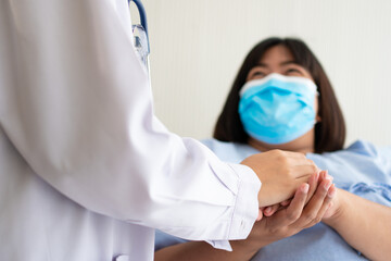 Women Asian doctors hold the patient hand and encourage and provide medical advice While checking...