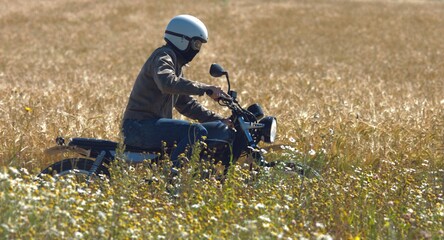 motorcyclist rides through a beautiful field