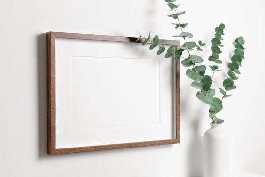 Wooden frame mockup on white wall with copy space for artwork, photo or print presentation.