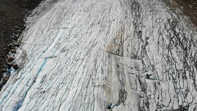 Aerial flyover above Stein glacier at Sustenpass, Switzerland with a view of the crevasses and the beginning of the glacier at Sustenhorn