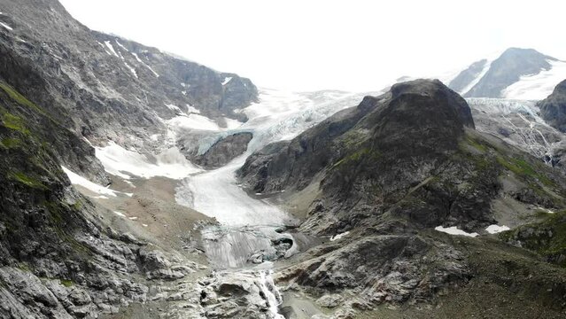 Aerial flyover away from Stein glacier at Sustenpass, Switzerland with a view of tall peaks of the Swiss Alps