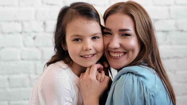 Happy cute affectionate adopted little kid girl hugging foster care parent mother with eyes closed, adorable small child daughter embrace mum cuddling enjoy tender sweet moment concept, close up view