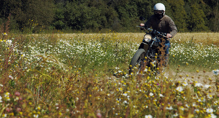 motorcyclist rides through a beautiful field