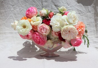 Vase of romantic vintage style roses on linen background