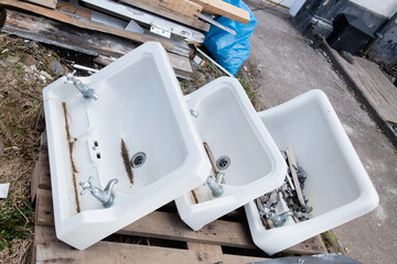 Fototapeta na wymiar Three traditional old bathroom sinks at house renovation. Vintage UK sinks. House clearing.