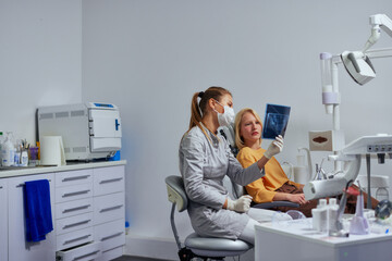 Female dentist and patient looking at x-ray picture