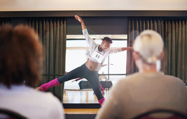 Moving to the music. Shot of a female dancer performing before the judges during a dance audition.