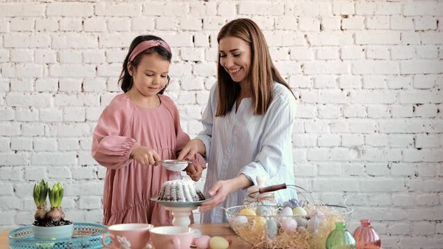 The girls' hands are sitting on the ester. The mouth of the festival is Esther Brad Into Pieces. The girl decorates Esther Brad.
