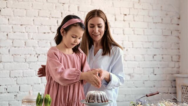 The girls' hands are sitting on the ester. The mouth of the festival is Esther Brad Into Pieces. The girl decorates Esther Brad.