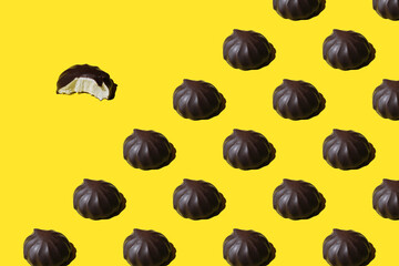 pattern of marshmallows in chocolate. Repeating Chocolate covered marshmallows on yellow background