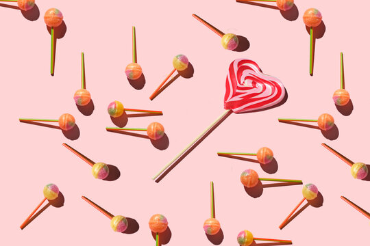 Colorful Set of Lollipops and chocolate. pattern made with caramel on a stick and chocolate on bright pink background.  creative pattern.  Sweet dessert.