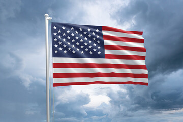 USA flag on a flagpole waving in the wind on a cloudy sky background. Flag of United States of America