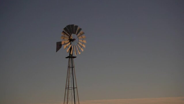 A ranch windmill against a clear blue sky