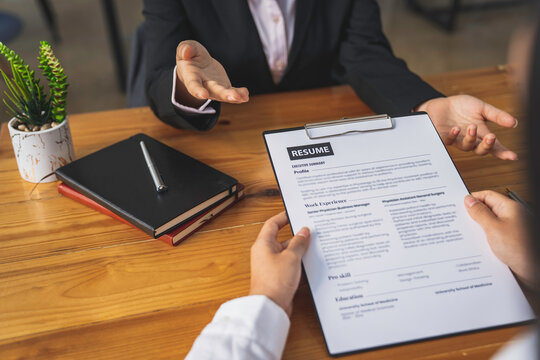 Employer or recruiter holding reading a resume during about colloquy his profile of candidate, employer in suit is conducting a job interview, manager resource employment and recruitment concept.