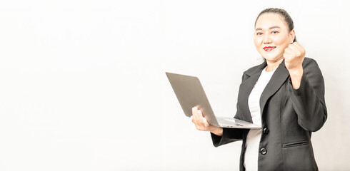 selective focus businesswoman smiling and looking at camera holding a laptop computer, standing, and handful, white background, close-up, copy space left, business, technology