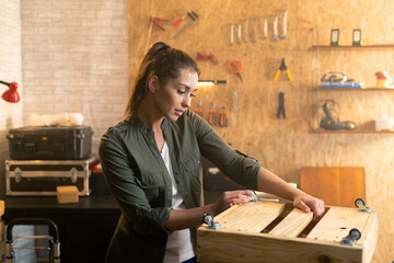 Portrait of woman in carpenter workshop with wooden tool box
