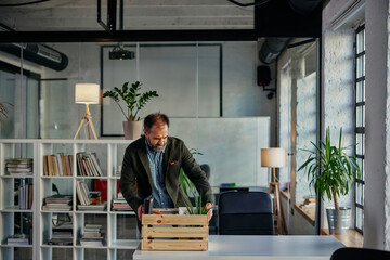 Businessman with belongings coming back in office