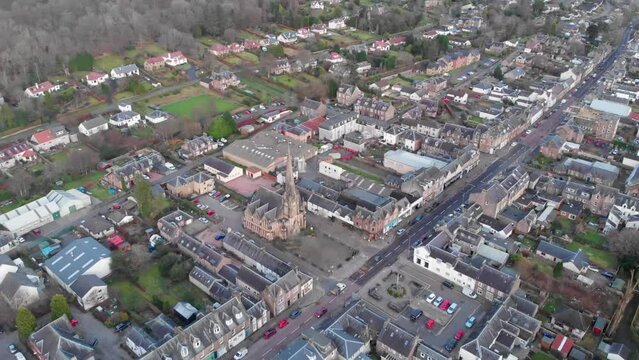 Drone footage. Flying over the center of Callander, a Scottish town. Flying over a church