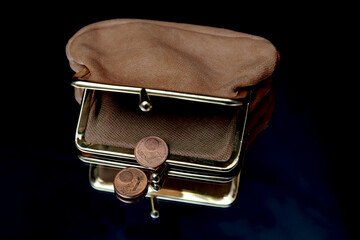 A purse and two one cent coins with black background