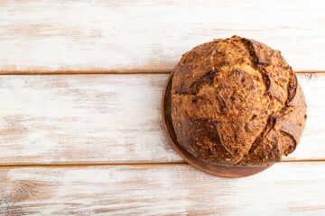 Fresh homemade golden grain bread with wheat and rye on white, top view, copy space.