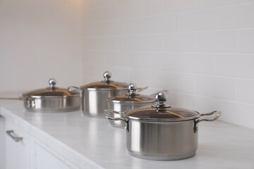 Set of new clean cookware on countertop in kitchen